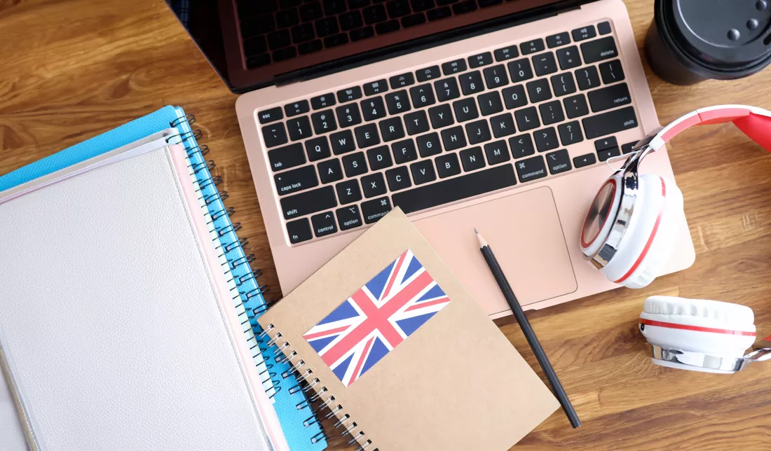 headphones-english-textbooks-lying-laptop-keyboard-closeup