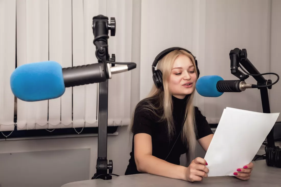 Prowadzaca audycje przy mikrofonie w studiu radiowym