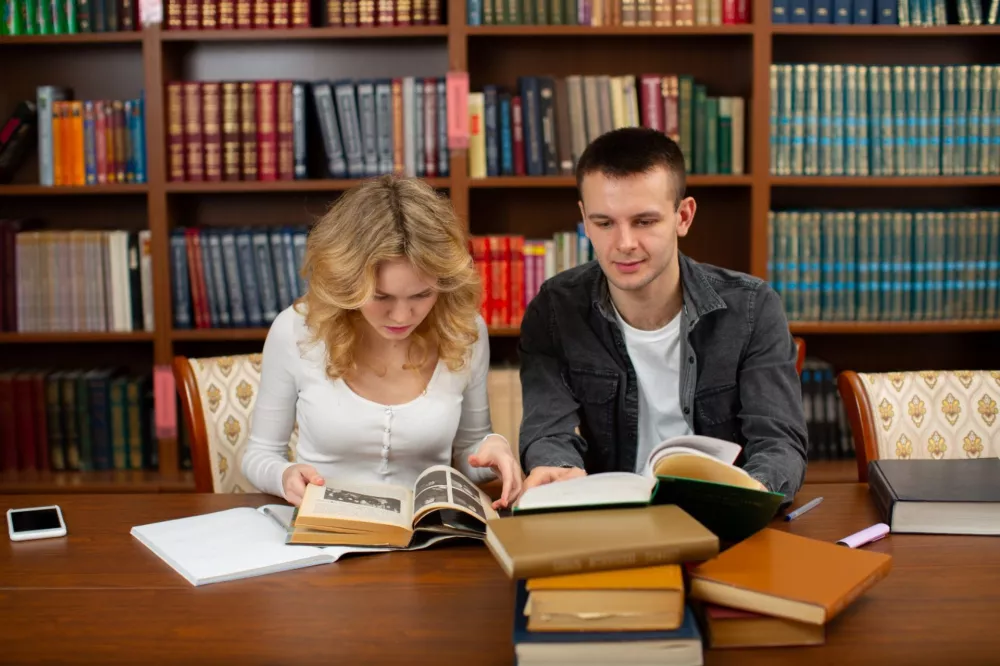 Studenci czytajacy ksiazki w bibliotece