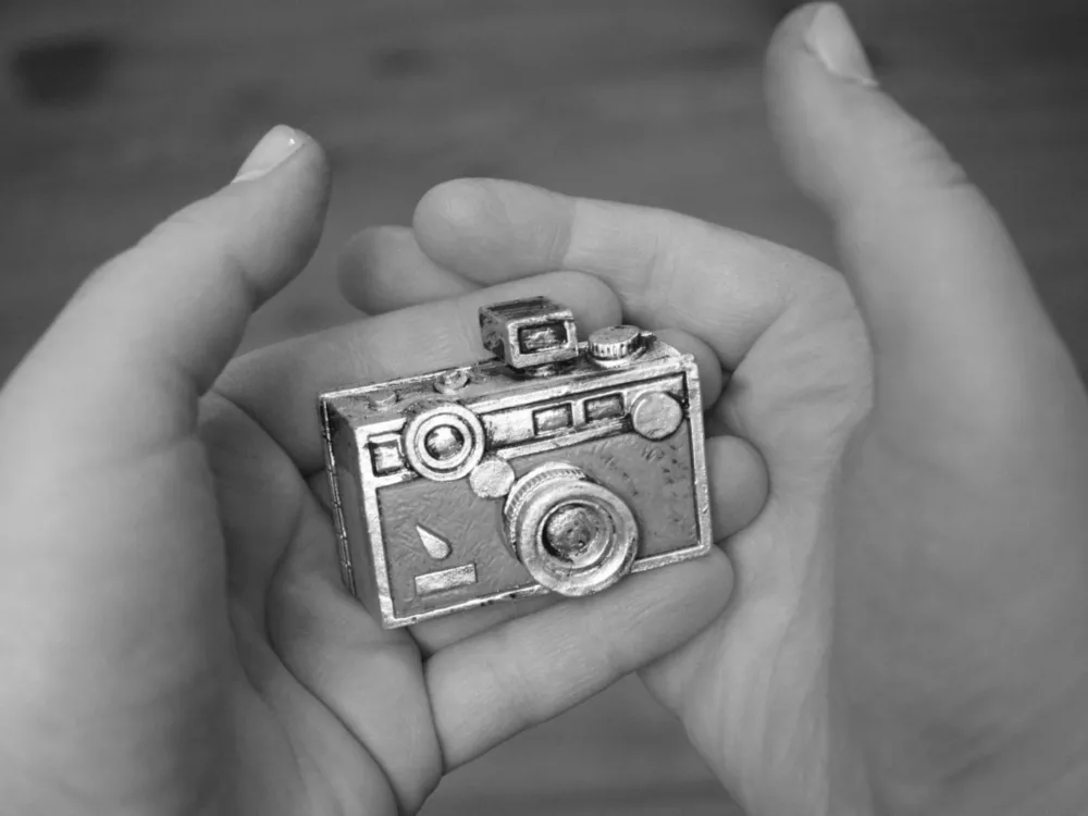 Figurka z aparatem fotograficznym w dloniach zdjecie z wystawy o dobrostanie psychicznym