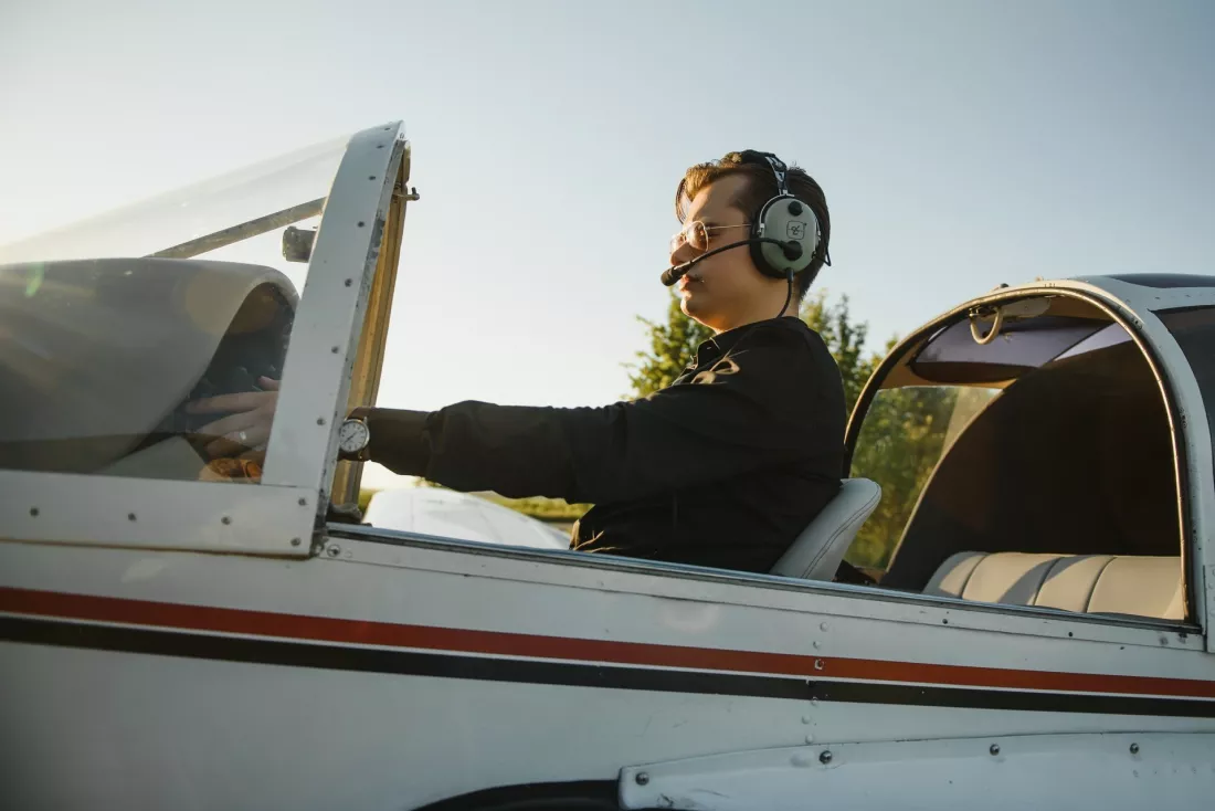Młody pilot w słuchawkach w kokpicie małego samolotu