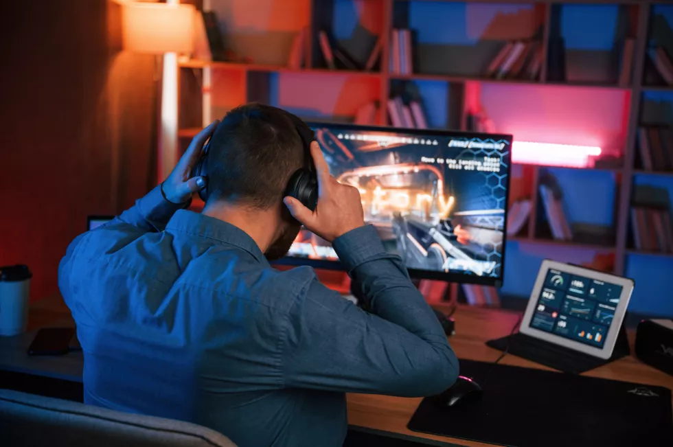 man-is-playing-shooter-game-his-computer-neon-lighting